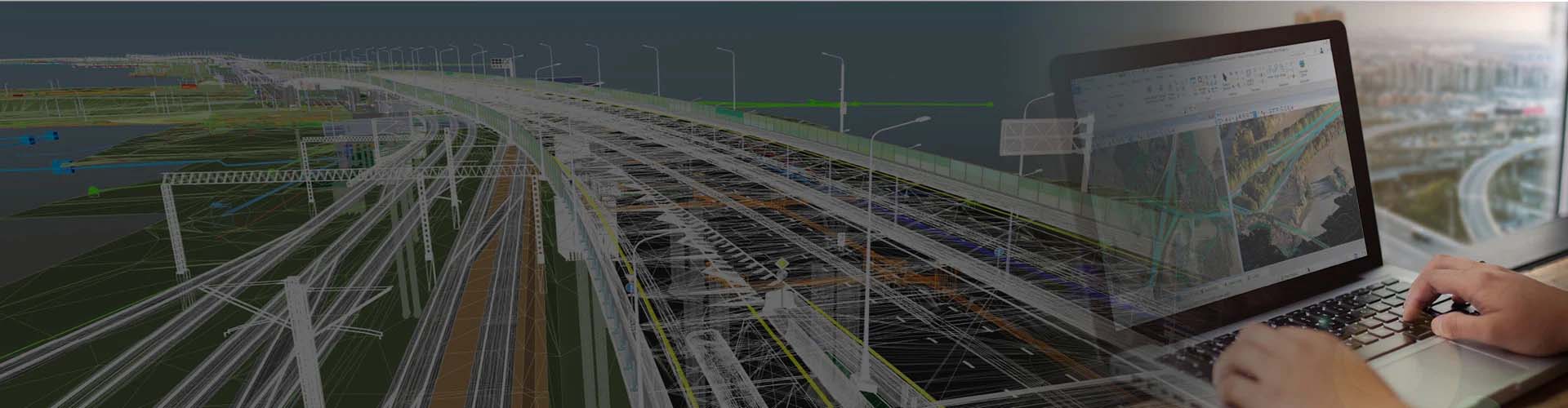 A person uses a laptop showing a 3D modeling software, likely MicroStation, to design or review an infrastructure project. The modeled image of a bridge is visible alongside the software interface, suggesting a focus on bridge design.